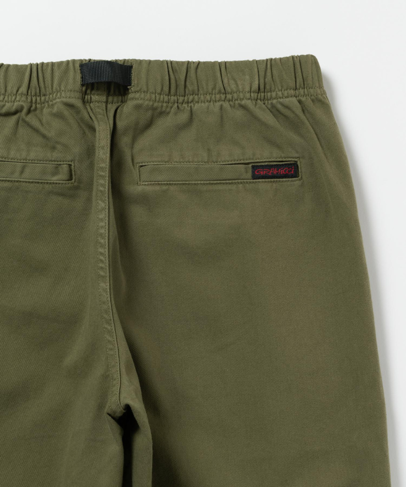 Close-up back view of olive green pants featuring a red Gramicci logo.
