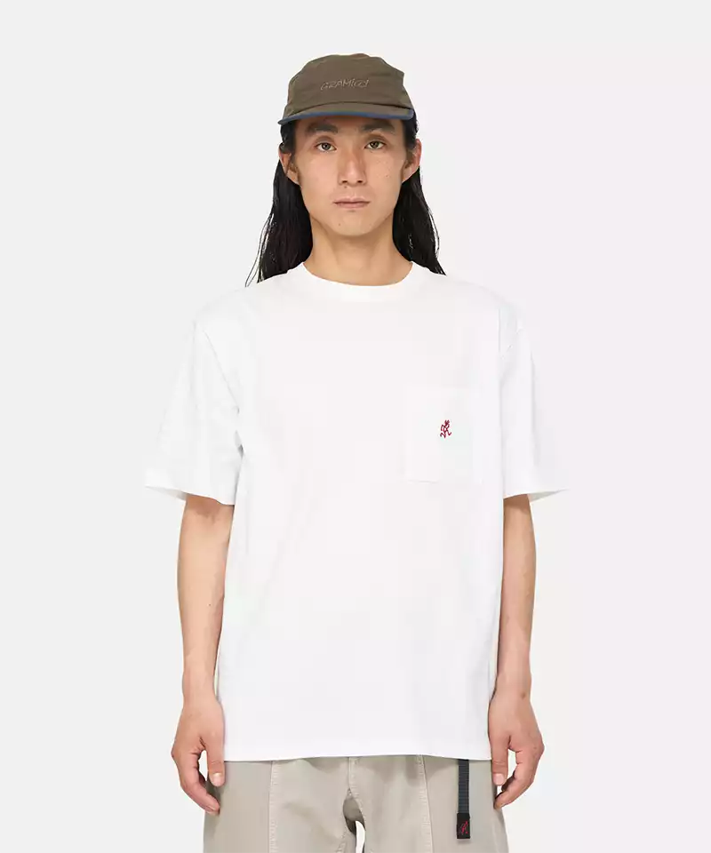 Model wearing a Gramicci white One Point Tee with a small running man graphic against a light-tone background.
