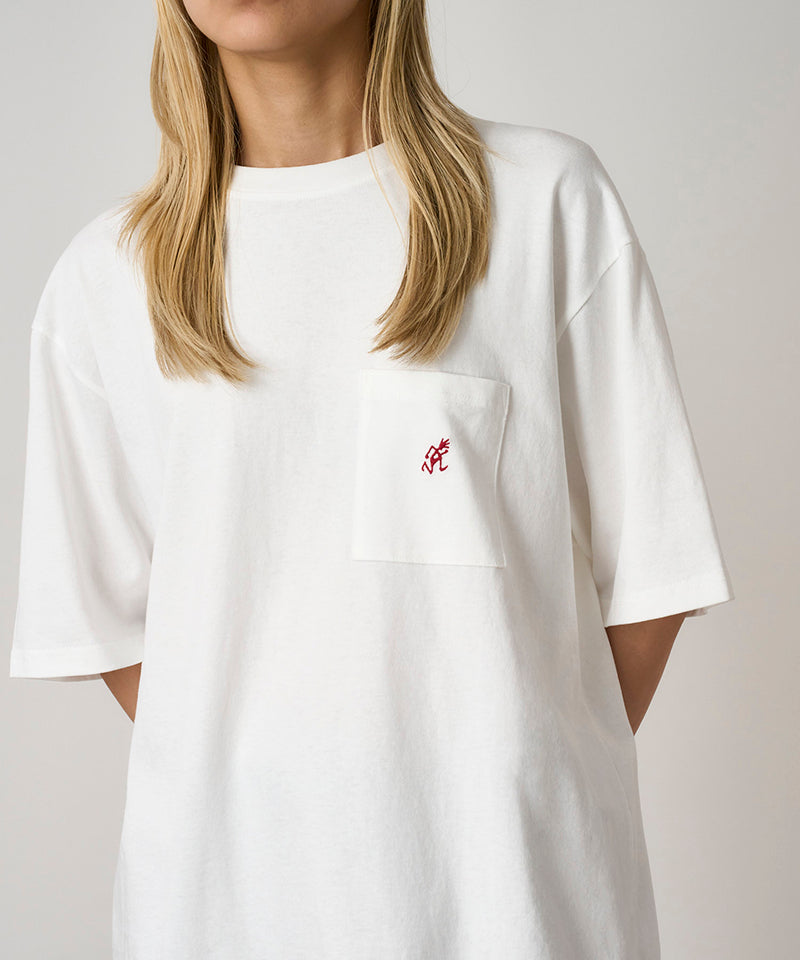 Model wearing a Gramicci white One Point Tee with a small running man graphic against a light-tone background.