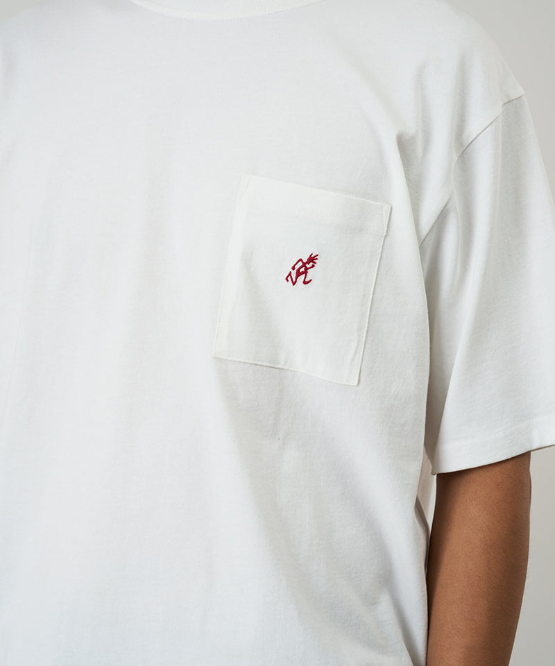 Model wearing a Gramicci white One Point Tee with a small running man graphic against a light-tone background.