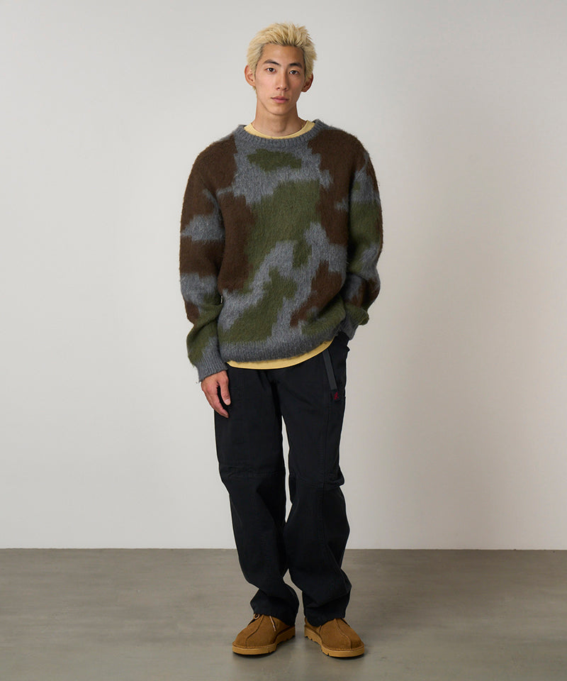 Model wearing black Gramicci Voyager Pants and a mohair sweater on a light-tone background.