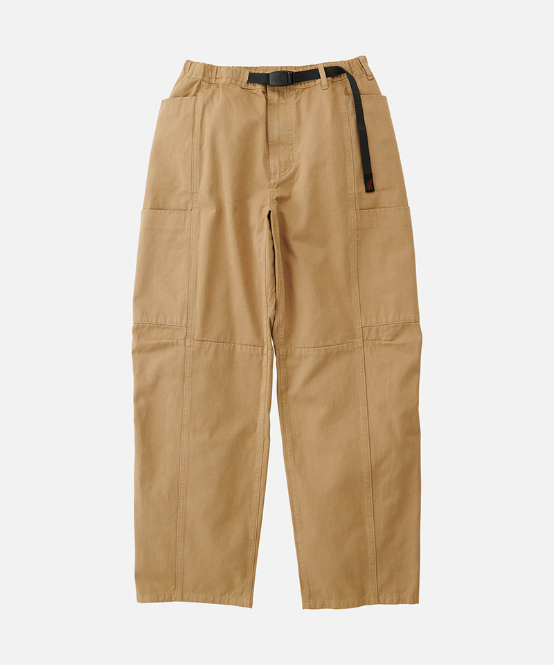 Chino colored Gramicci Voyager Pants with a belt against a light-tone background.