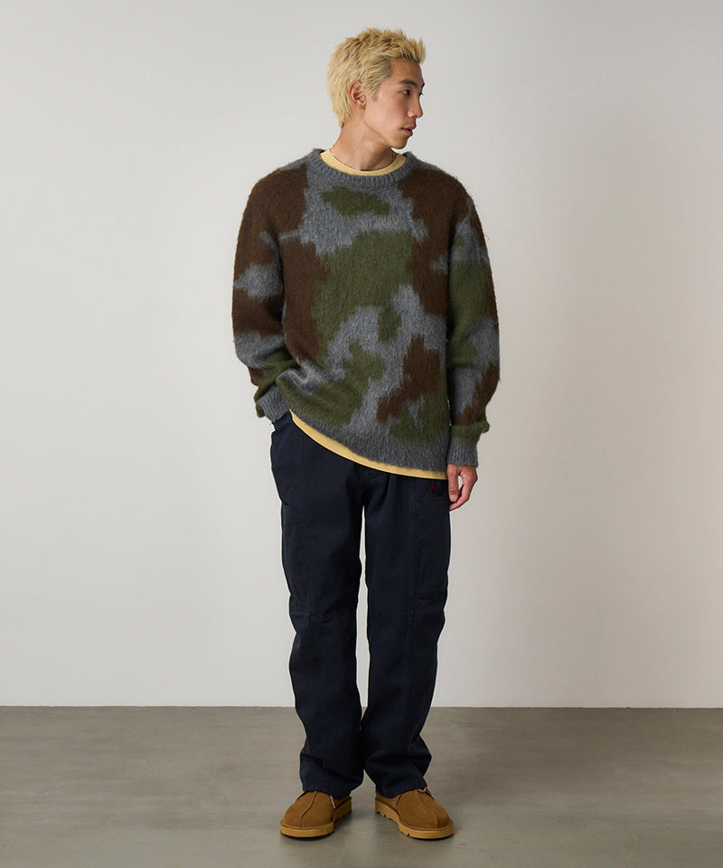 Model wearing double navy Gramicci Voyager Pants and a mohair sweater on a light-tone background.