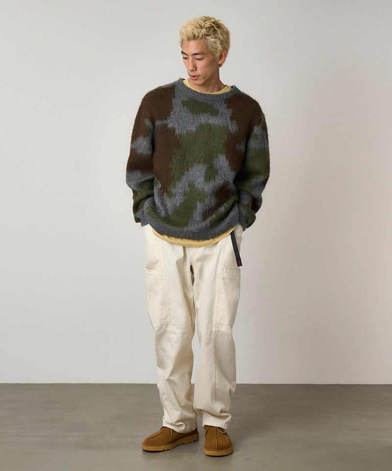 Model wearing greige colored Gramicci Voyager Pants and a mohair sweater on a light-tone background.