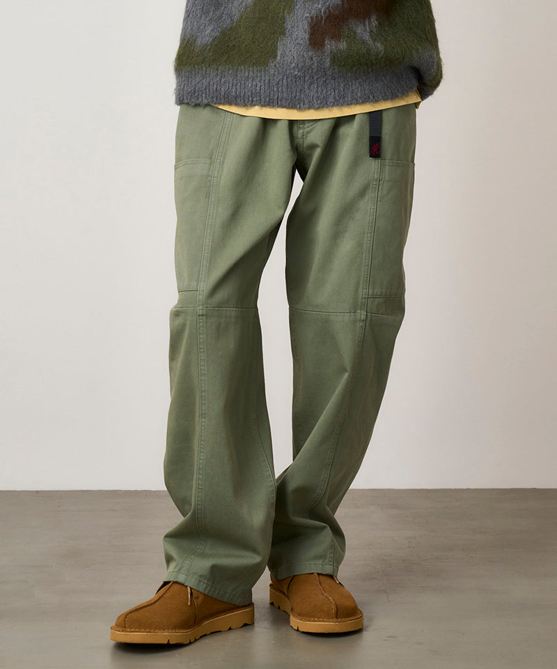 Model wearing sage colored Gramicci Voyager Pants and a mohair sweater on a light-tone background.