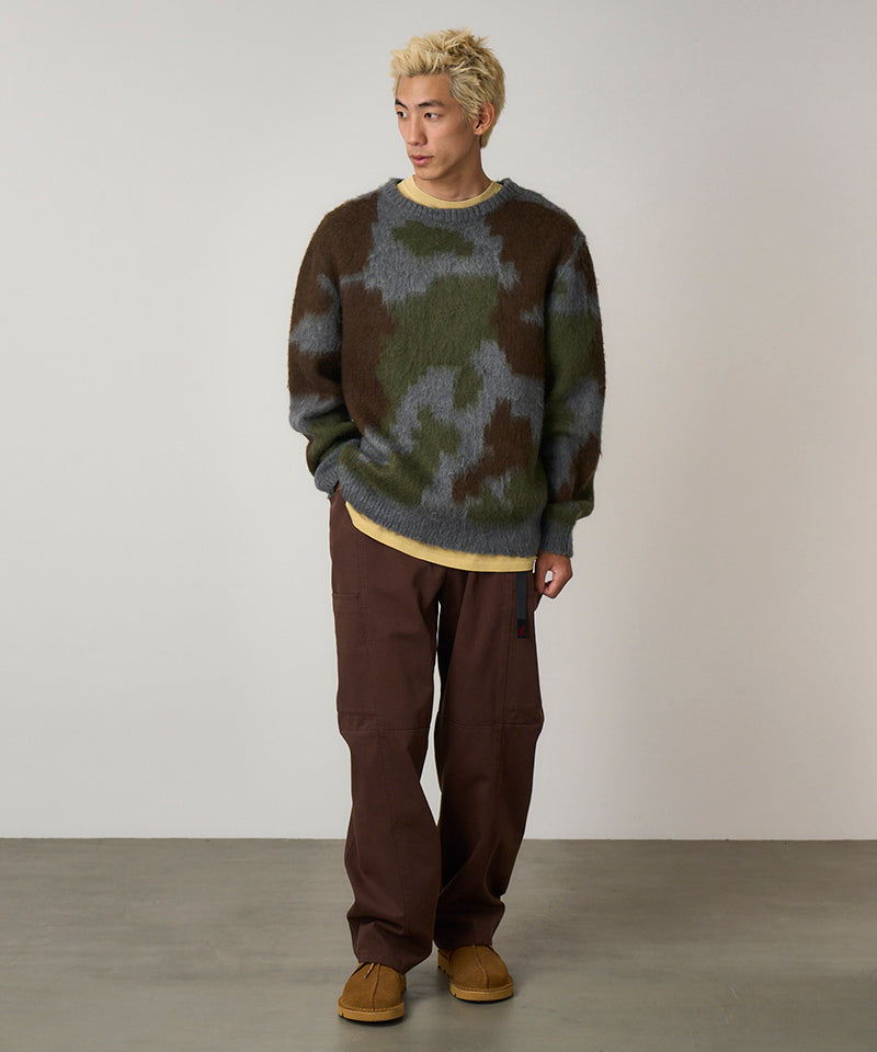 Model wearing tobacco colored Gramicci Voyager Pants and a mohair sweater on a light-tone background.