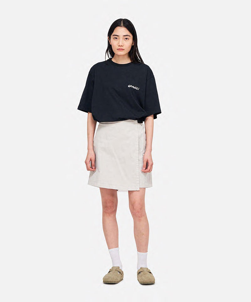 Model wearing a Gramicci G-Skort in the color dune grey and a black shirt on a light-tone background.