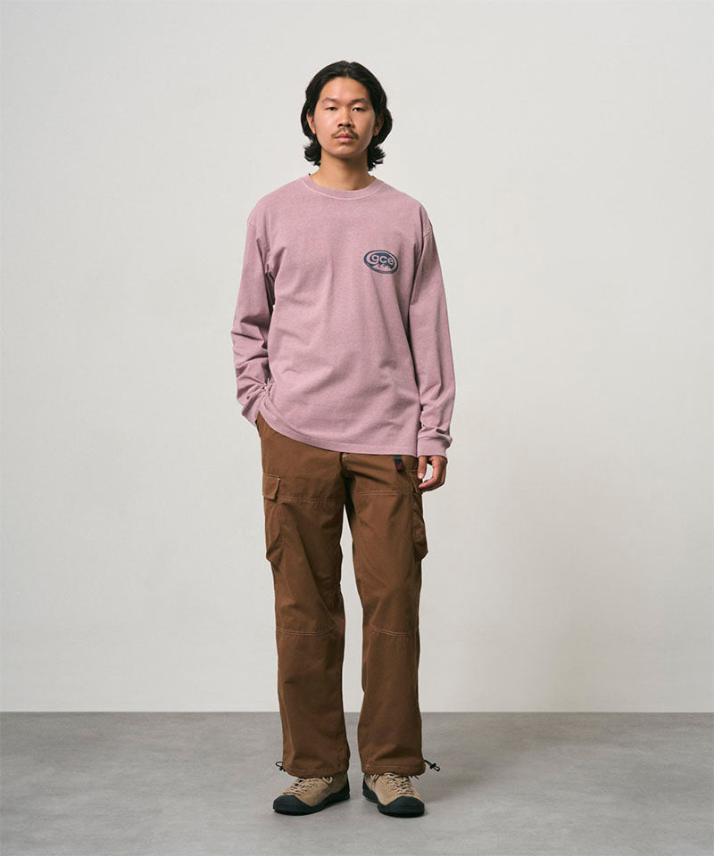 Model wearing a lilac pigment Gramicci GCE Long Sleeve Tee Pigment Dyed and brown pants on a light-tone background.