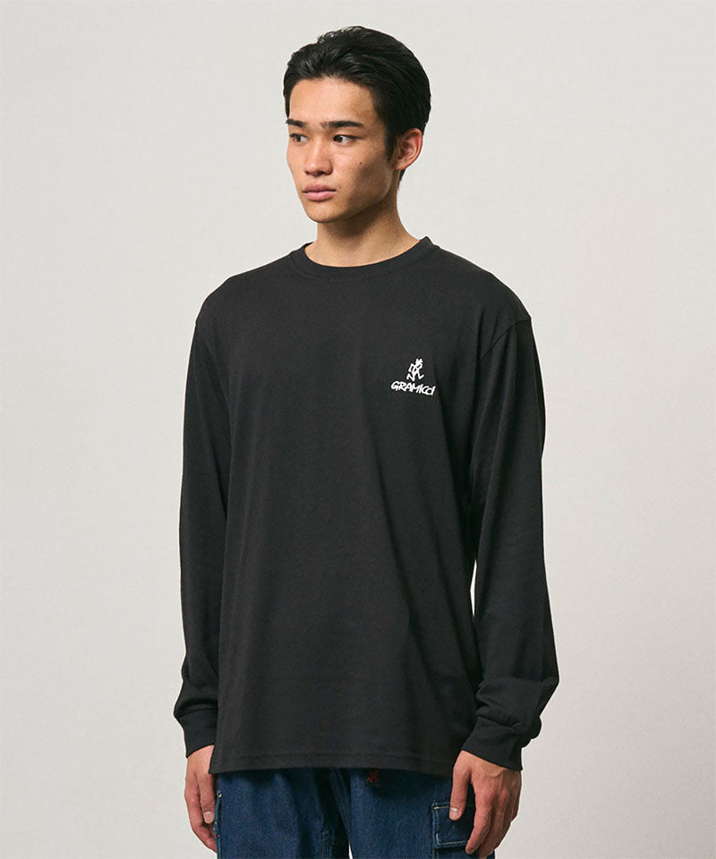 Model wearing a Gramicci black One Point Logo Long Sleeve Tee with a graphic against a light-tone background.