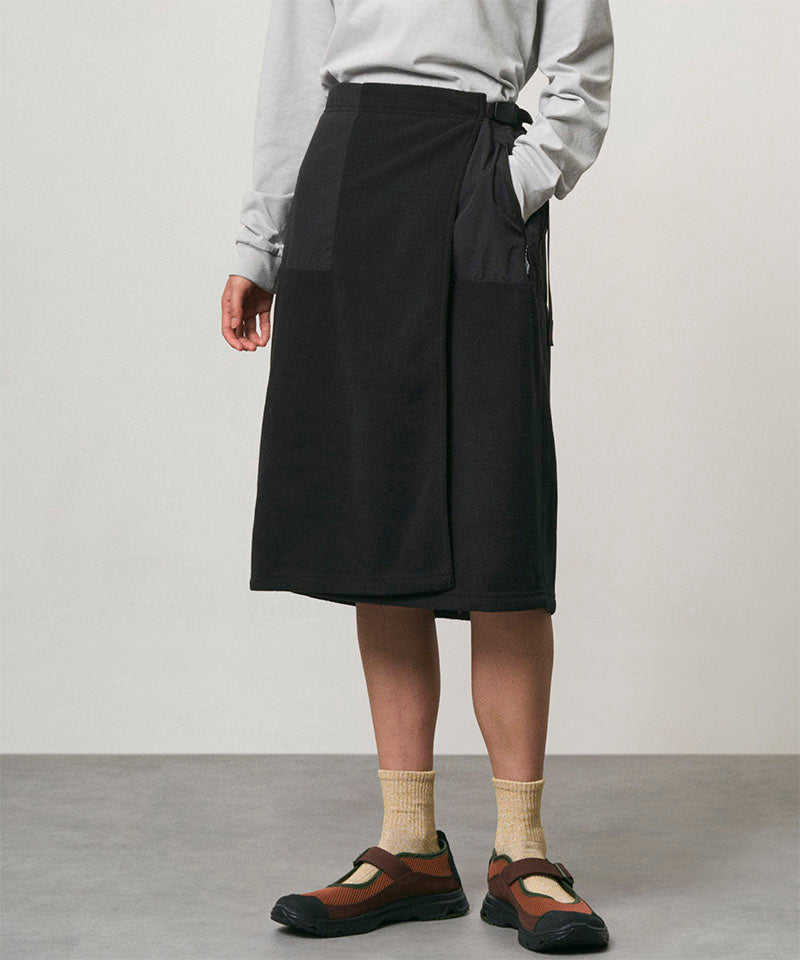 Model wearing a black Gramicci Thermal Fleece Skirt and a grey sweatshirt on a light-tone background.