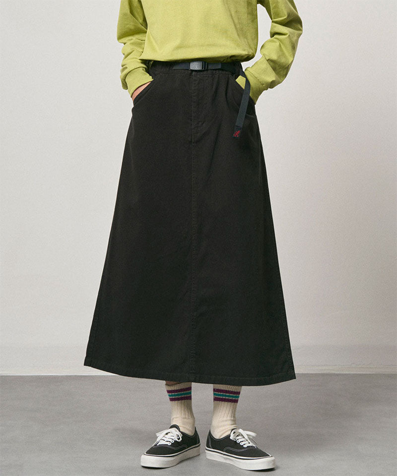 Model wearing a black Gramicci 5-Pocket Skirt and a brown vest on a light-tone background.