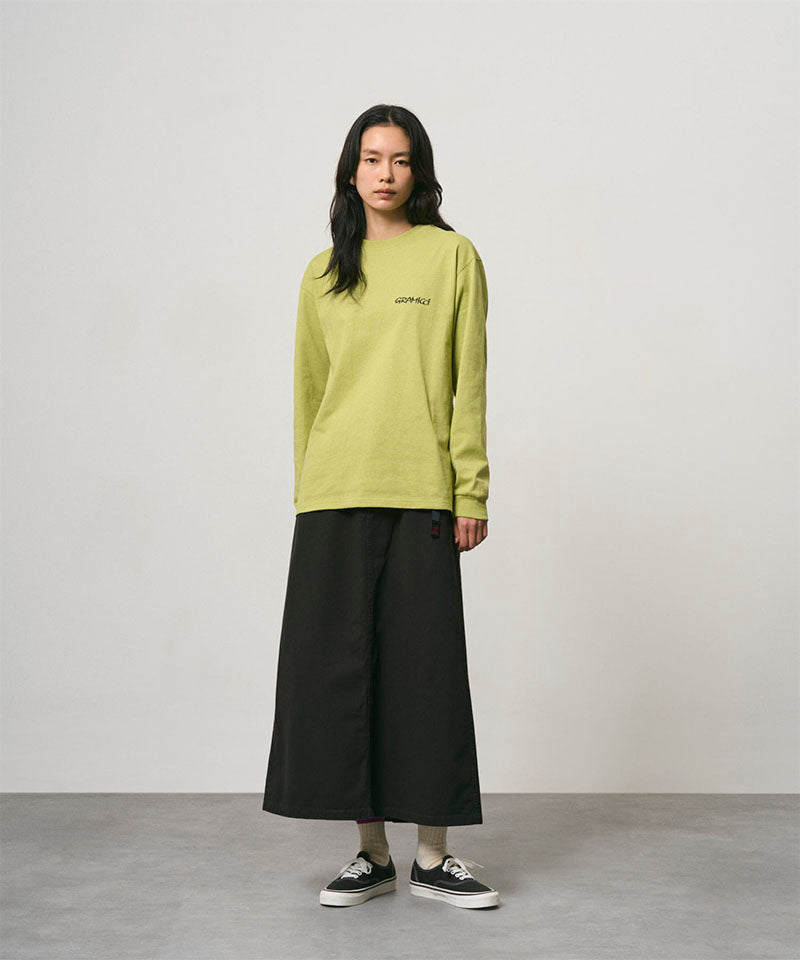 Model wearing a black Gramicci 5-Pocket Skirt and a lime green shirt on a light-tone background.