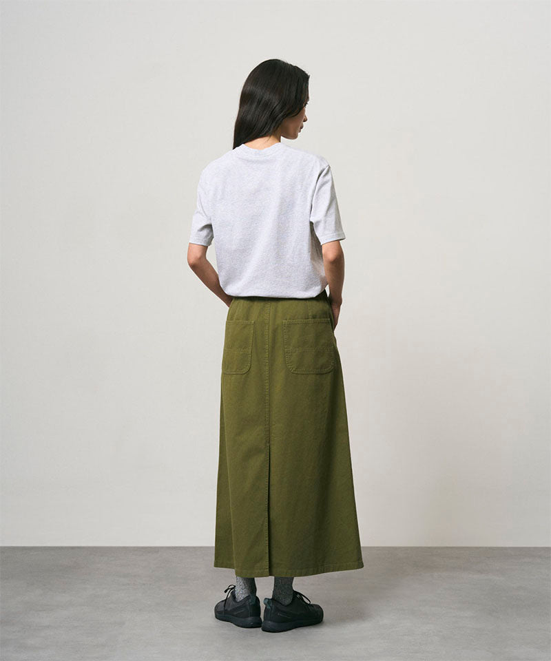 Back view of a model wearing a olive colored Gramicci 5-Pocket Skirt and a white shirt on a light-tone background.