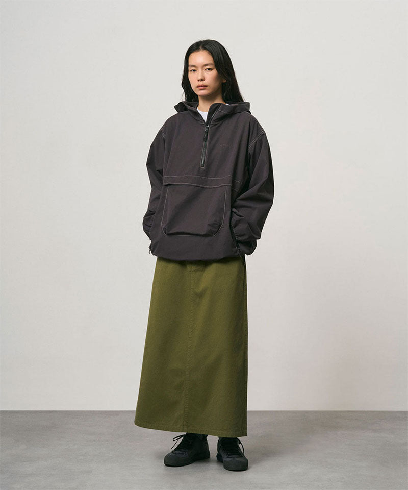 Model wearing a olive colored Gramicci 5-Pocket Skirt and a dark grey jacket on a light-tone background.