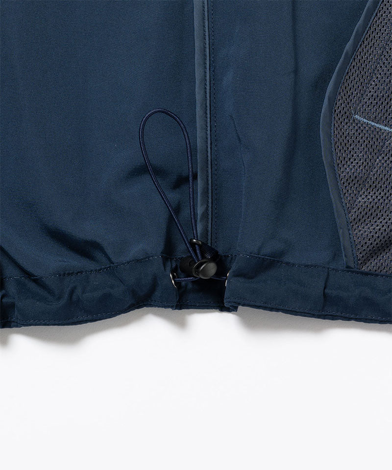 Close-up of a dark navy Gramicci Milton Hooded Jacket on a light-tone background.