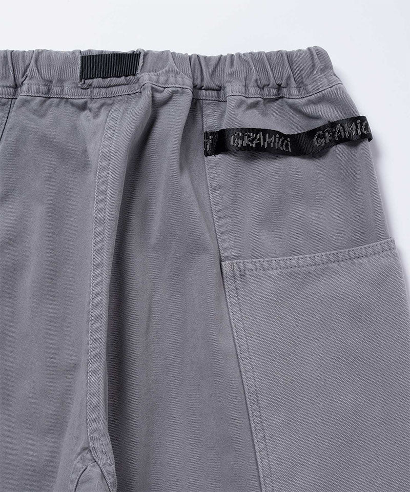 Back view close-up of natural dyed grey Gramicci Gadget Pants and Gramicci branding on a light-tone background.