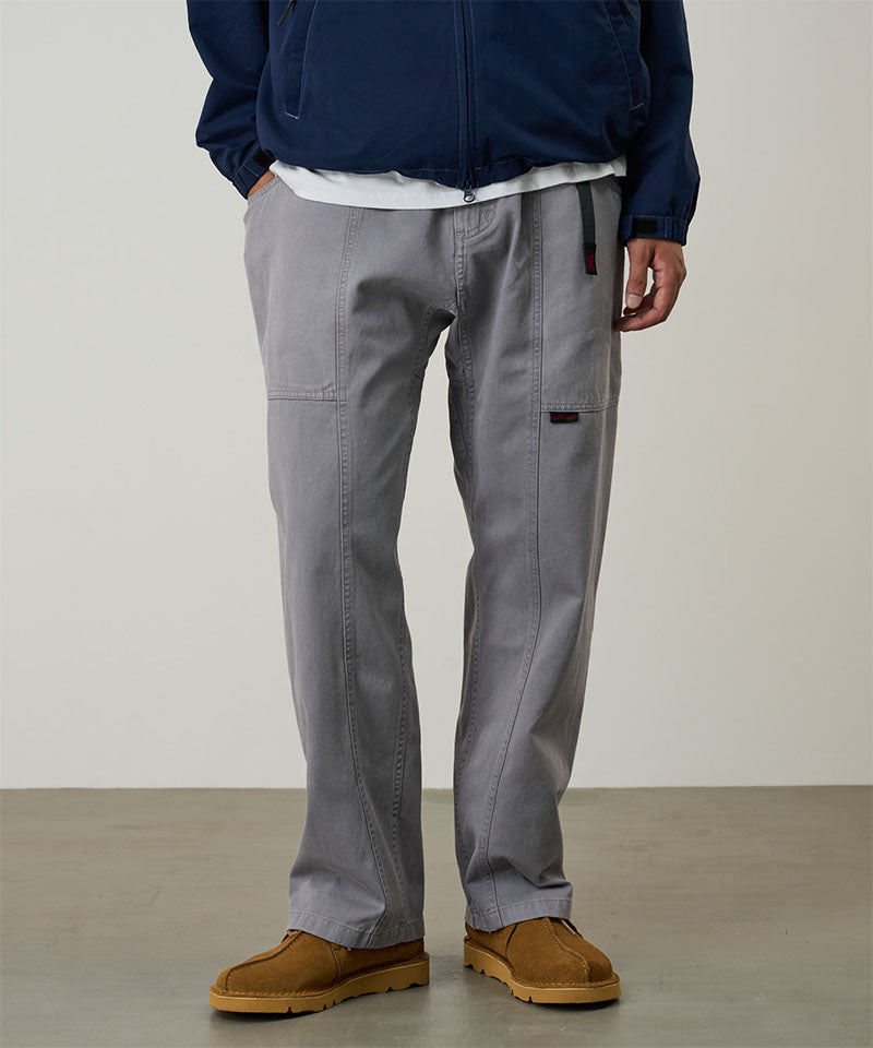 Model wearing a Gramicci natural dyed grey Gadget Pants against a light-tone background.