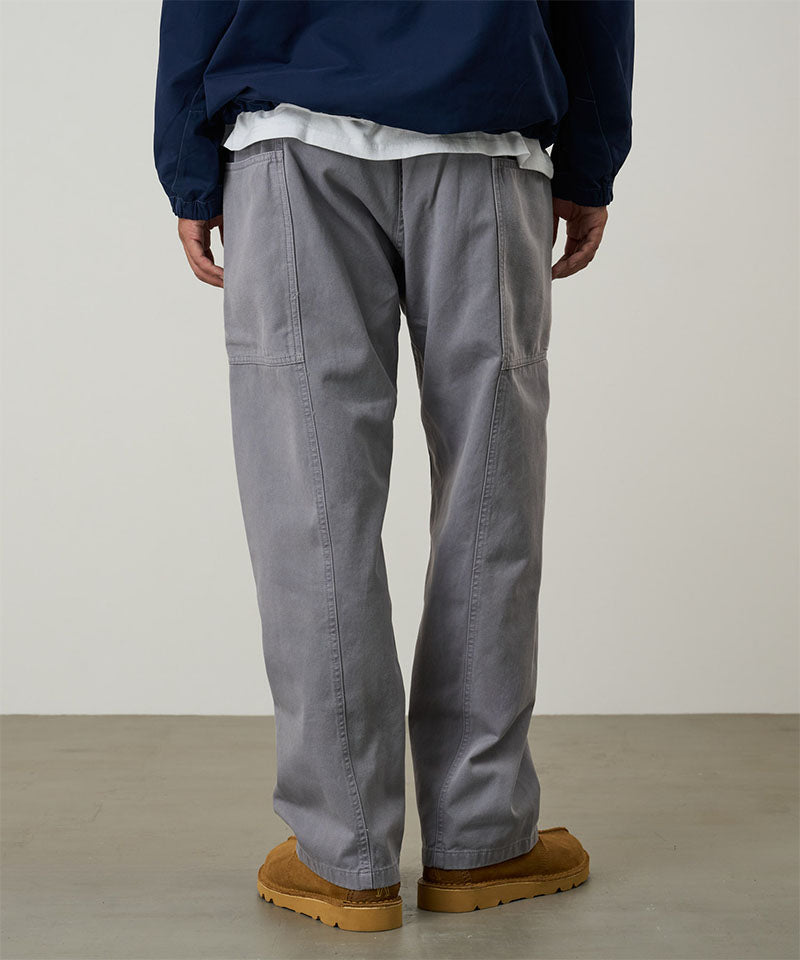 Back view of a model wearing a Gramicci natural dyed grey Gadget Pants against a light-tone background.