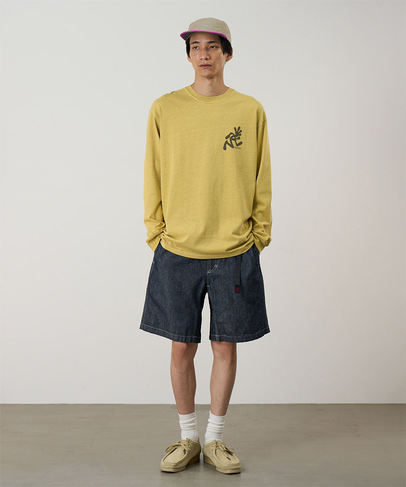 Model wearing navy Gramicci Japanese Chambray Shorts and a yellow shirt on a light-tone background.