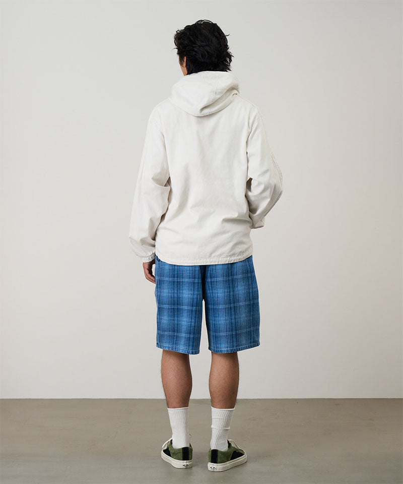 Back view of a model wearing a indego Gramicci Lagoon Short Denim Plaid and white jacket on a light-tone background.
