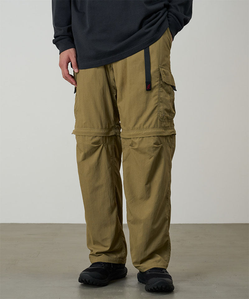Model wearing khaki Gramicci Convertible Cargo Pants and a black shirt on a light-tone background.