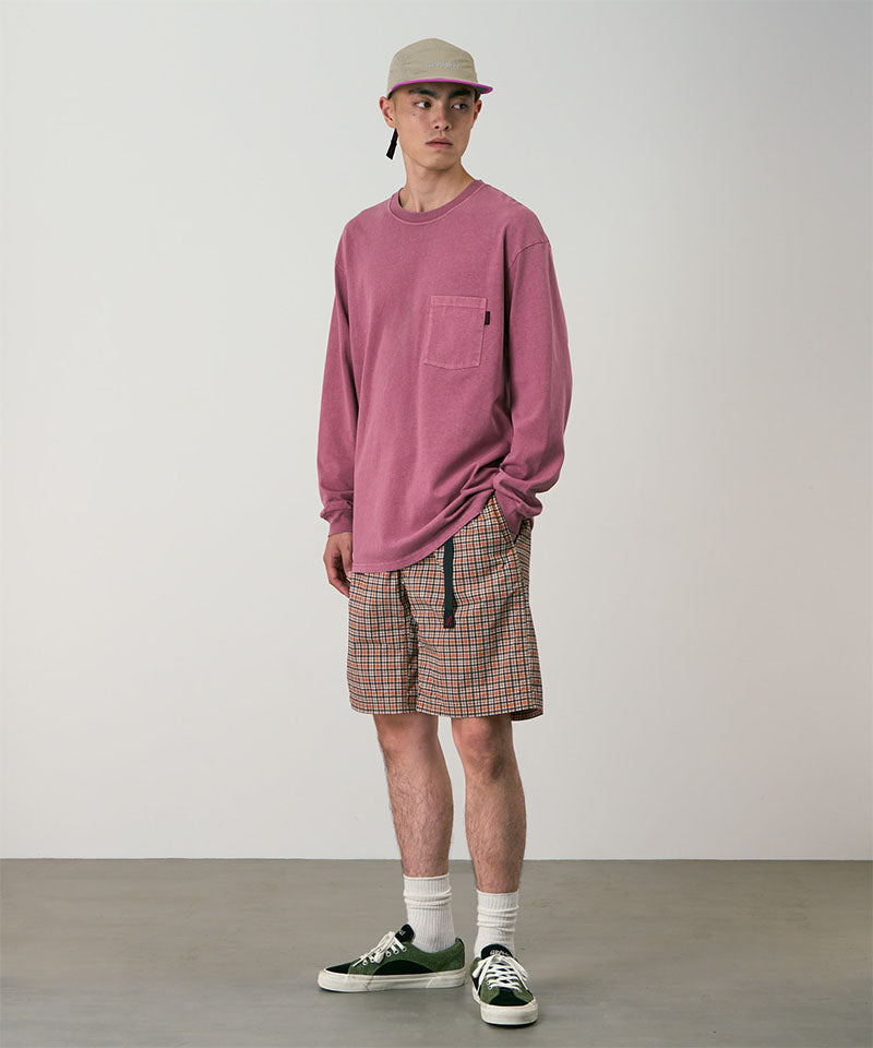 Model wearing brick check colored Gramicci Checkered Shell Shorts and a red shirt on a light-tone background.