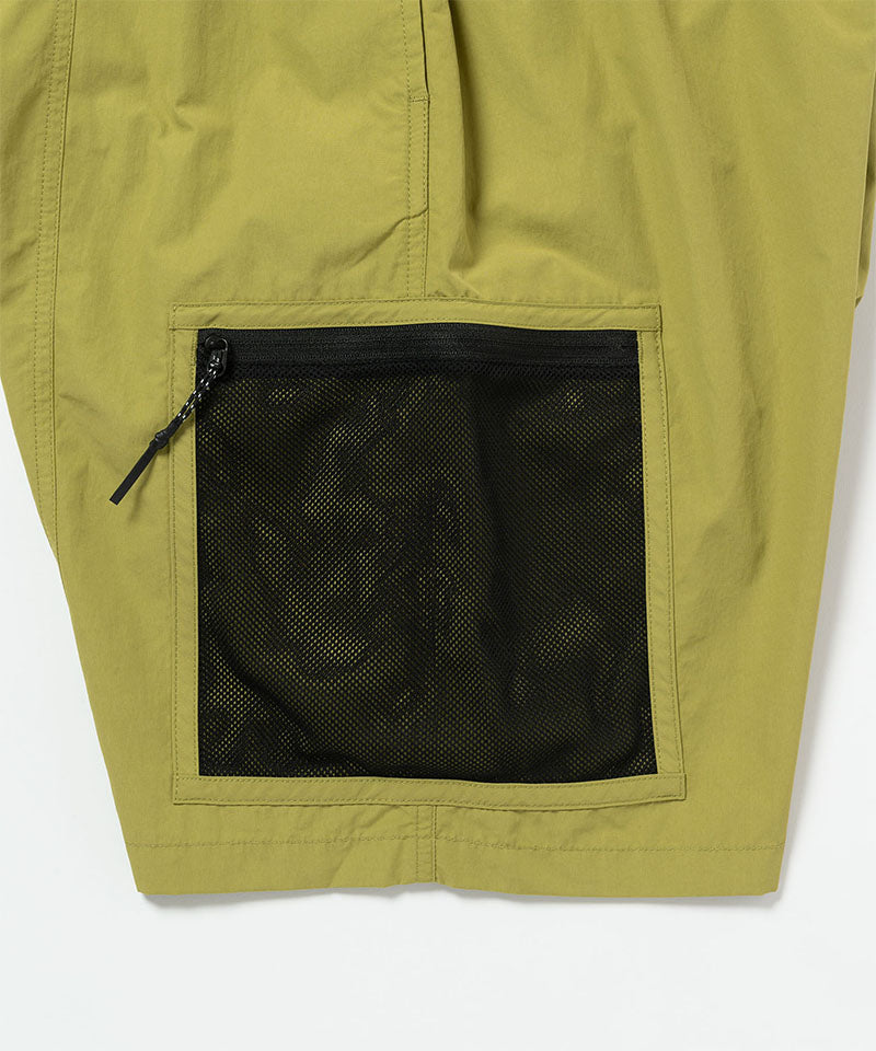 Field green Gramicci Guide Shorts hem showing the logo label on a light-tone background.