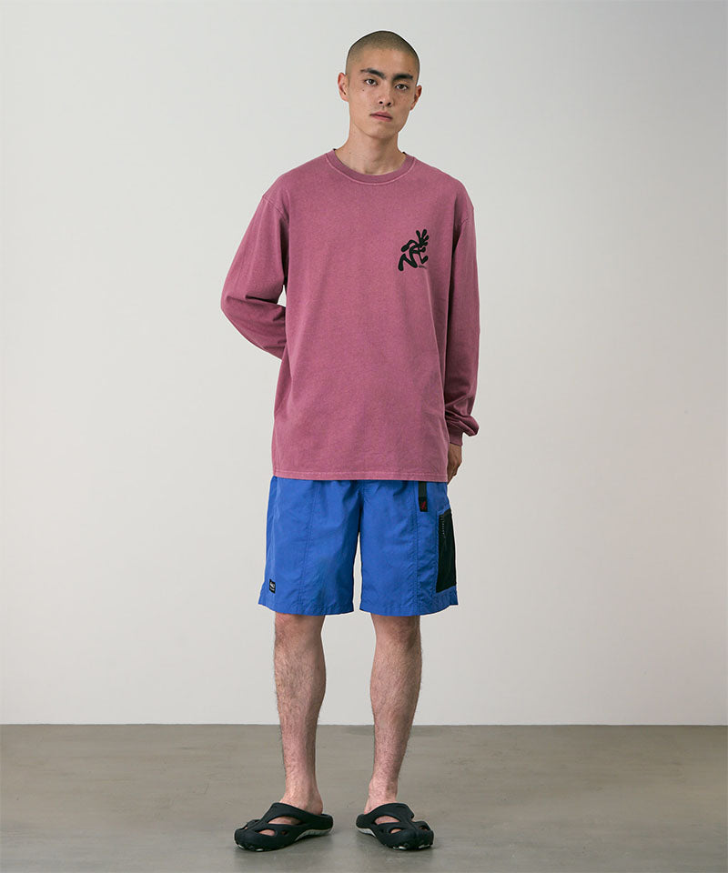 Model wearing navy blue Gramicci Guide Shorts and a red shirt on a light-tone background.