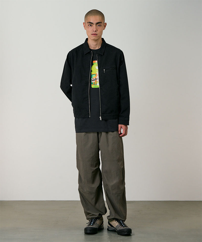 Model wearing granite colored Gramicci Nylon Paneled Trek Pants and a black jacket on a light-tone background.