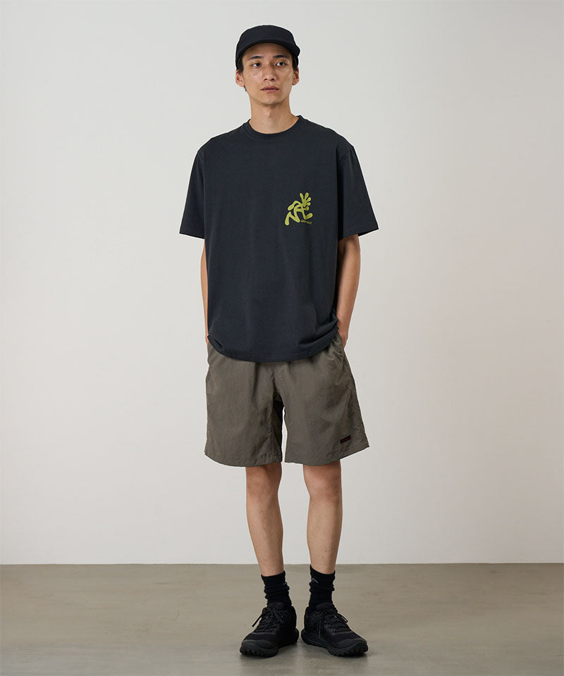 Model wearing granite colored Gramicci Nylon Reef Shorts and a black shirt on a light-tone background.