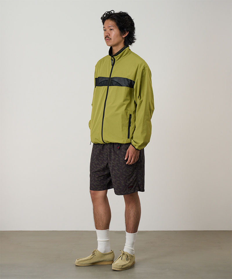 Model wearing brown leaf colored Gramicci Nylon Packable G-Short and a olive jacket on a light-tone background.