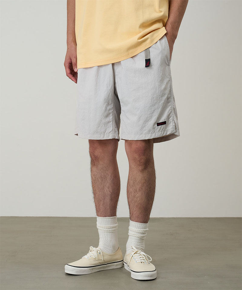 Half Model
Model wearing ecru colored Gramicci Nylon Packable G-Shorts and a mango colored shirt on a light-tone background.
