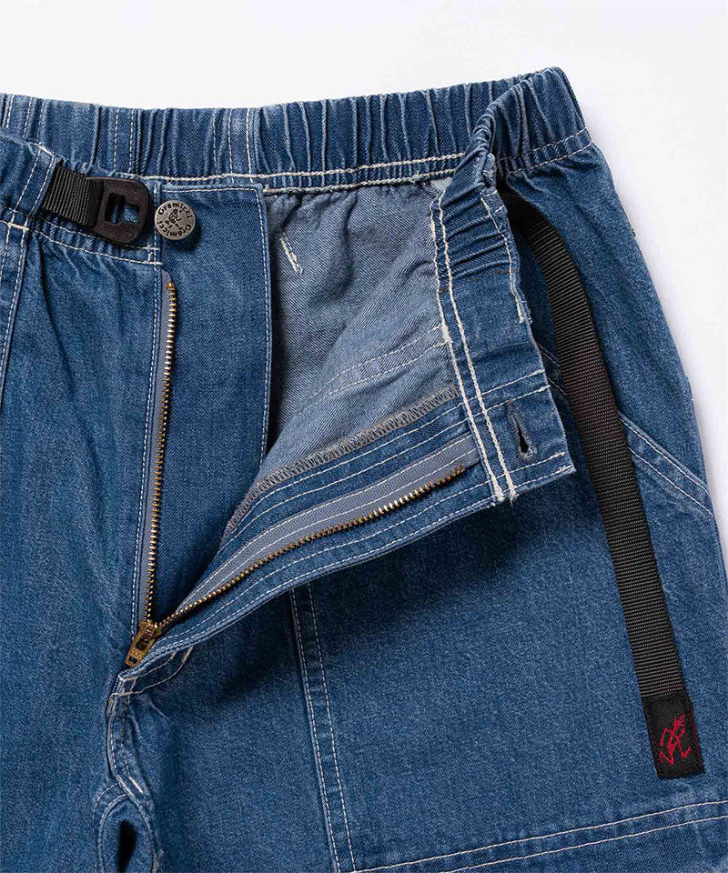 Close-up view of light wash colored Gramicci Gramicci Denim EQT Pant showing waistband and zipper detail on a light-tone background.