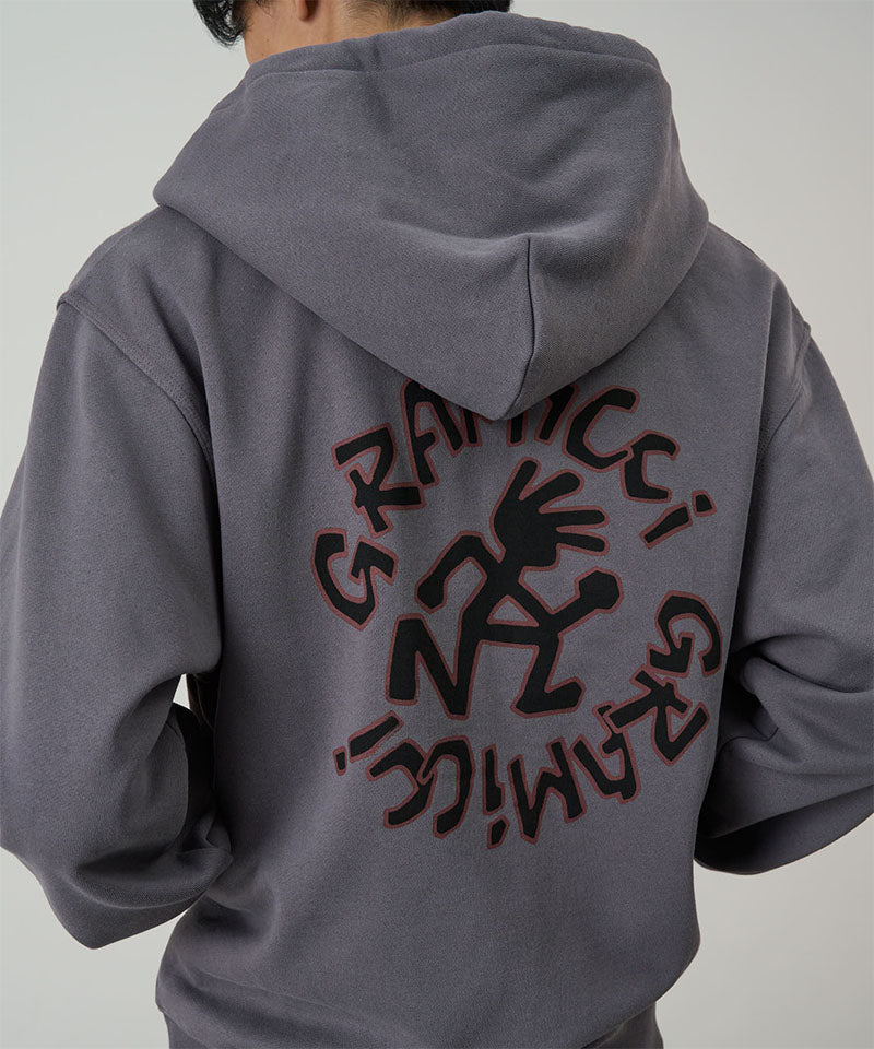 Back view of a model wearing charcoal Gramicci Running Man Zip Hooded Sweatshirt on a light-tone background.