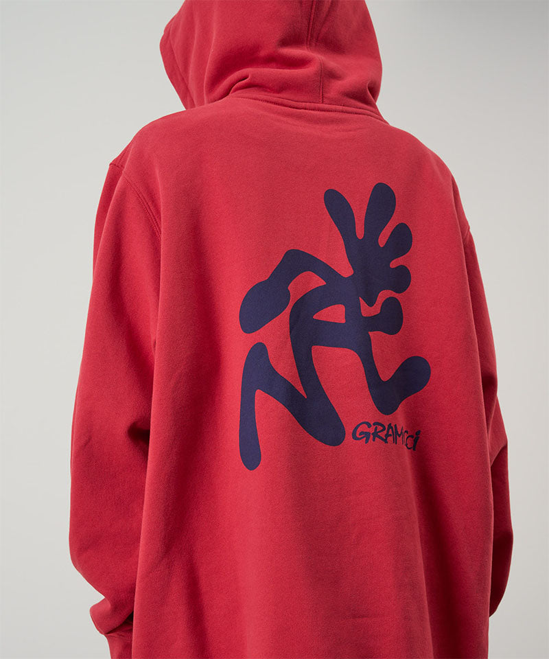 Back view of a model wearing a Gramicci crimson red Running Man Hooded Sweatshirt with blue running man graphic against a light tone background.