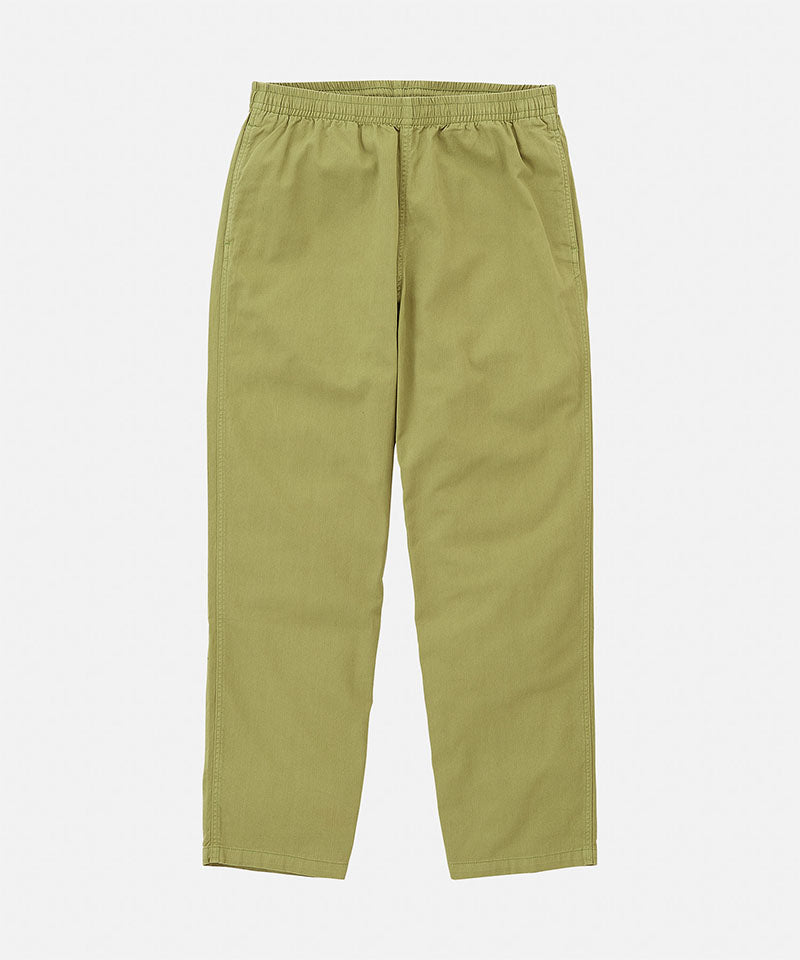 Grass colored Gramicci Swell Pant with a stretchy waistband against a light-tone background.