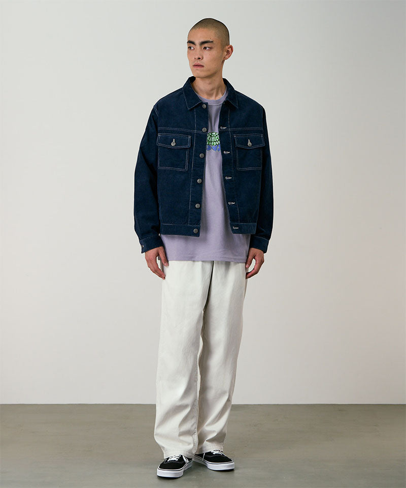 Model wearing stone colored Gramicci Swell Pant and a blue denim jacket on a light-tone background.