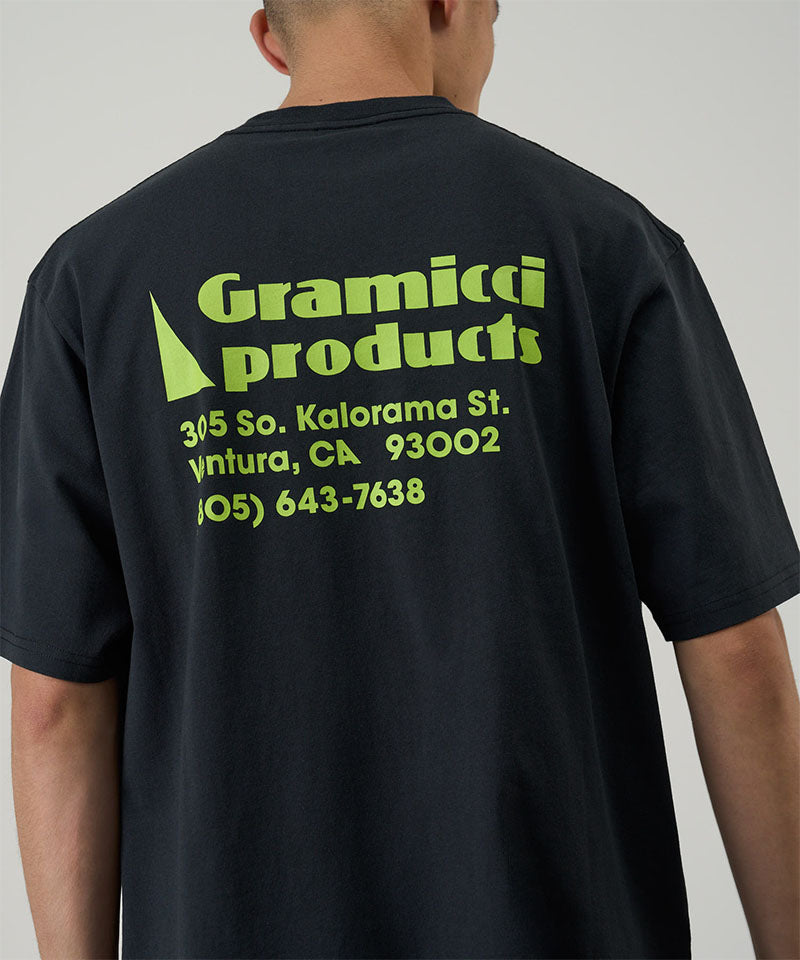 Back view of a model wearing a Gramicci vintage black G-Sail Tee with a yellow graphic against a light-tone background.