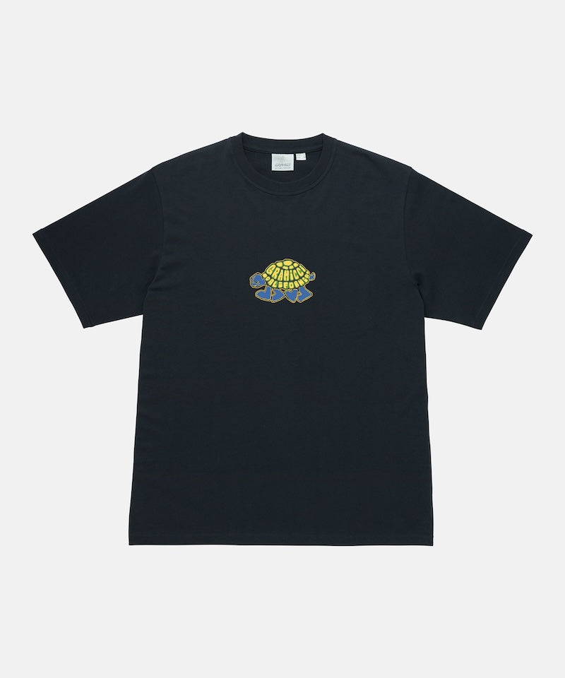 Gramicci vintage black Turtle Tee with a turtle graphic against a light tone background.