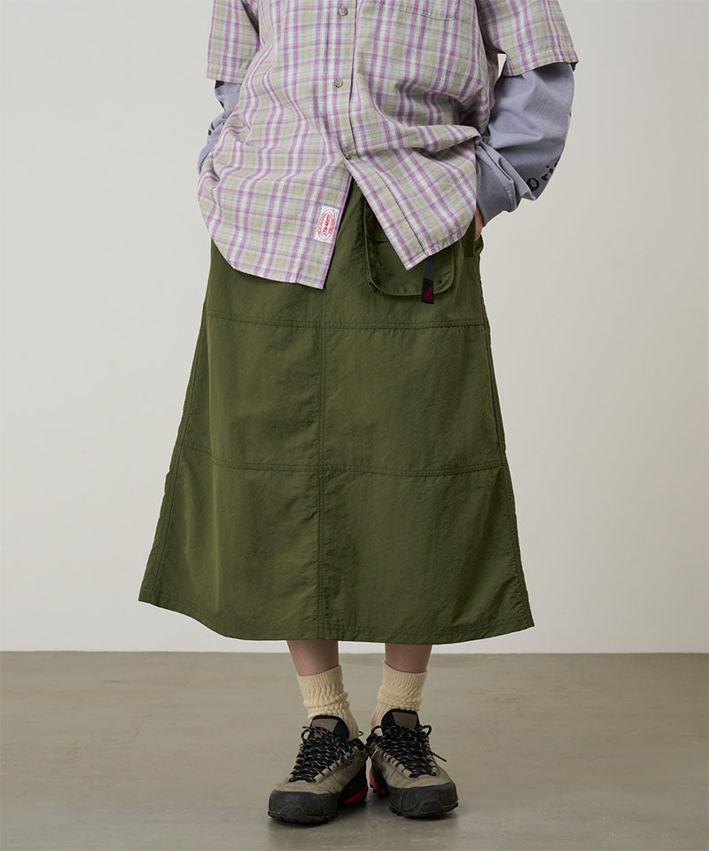 Model wearing a Gramicci olive Nylon Utility Skirt against a light-tone background.