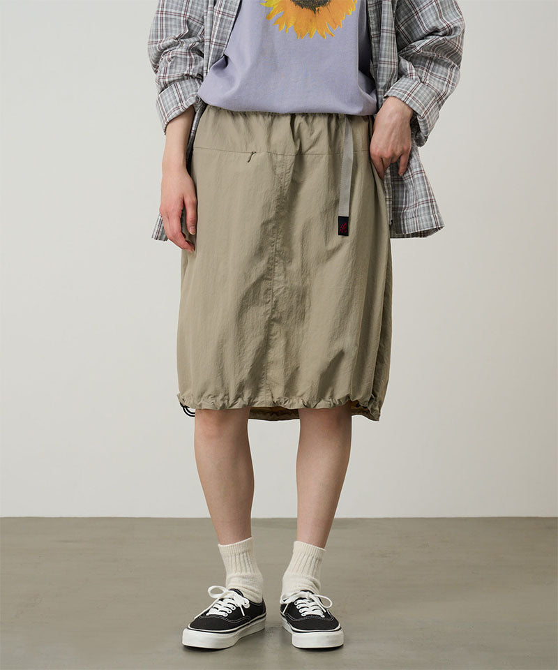 Model wearing a Gramicci milk tea colored Nylon Packable Midi Skirt against a light-tone background.