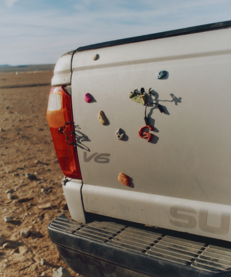 Back of an off-white SUV with Gramicci rock climbing magnets in a desert setting.