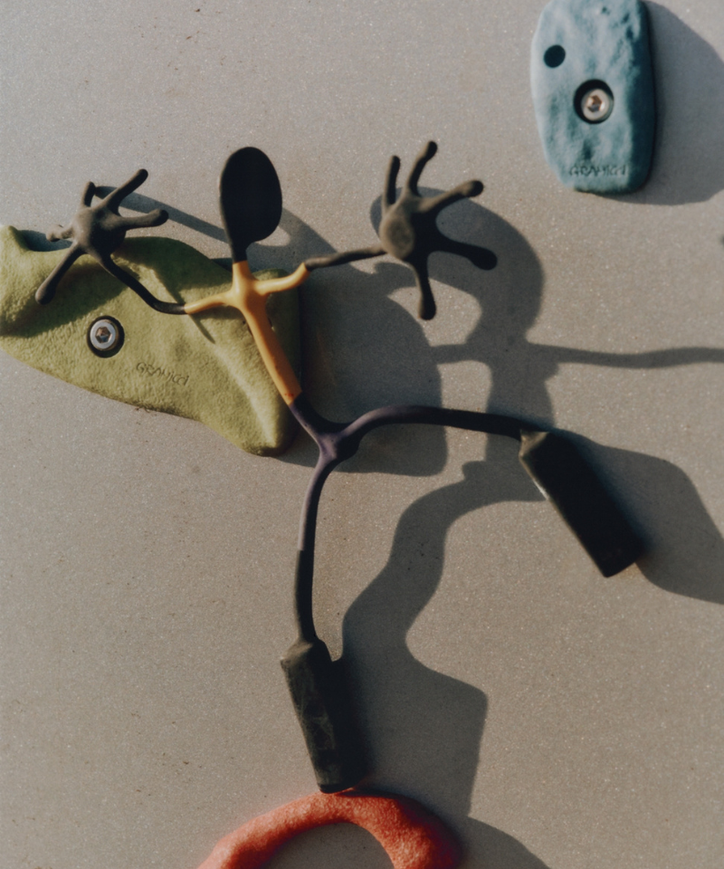 Close-up of a unique, abstract sculpture on a rock climbing wall.