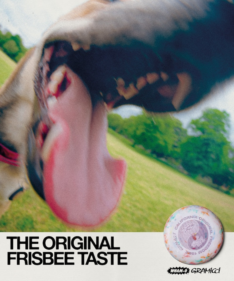Dog with a long tongue licking its nose, with text 'The Original Frisbee Taste' and a Gramicci logo at the bottom.