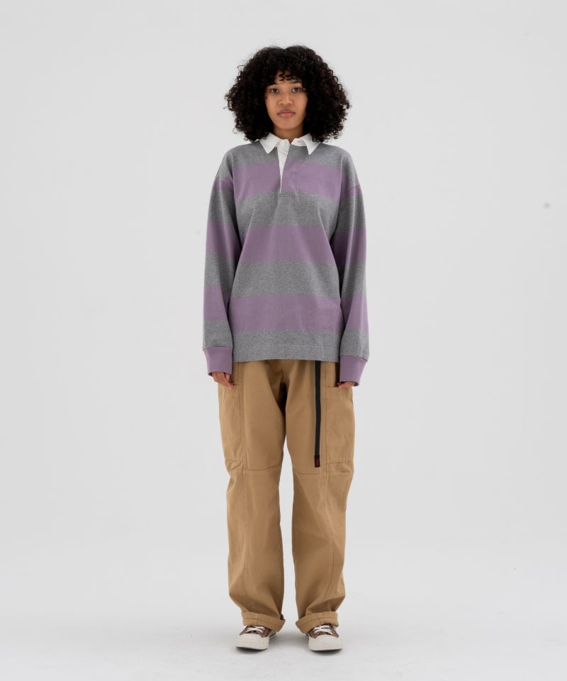 Model wearing beige Gramicci Voyager Pants and a lavender and grey stripped Gramicci Langdon Rugby Long-Sleeve shirt on a light-tone background.