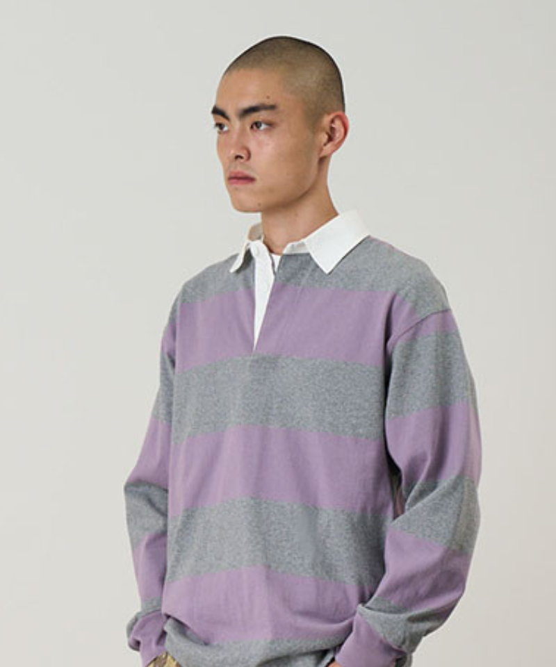 Model wearing a Gramicci heather and purple stripped Gramicci Langdon Rugby Shirt against a light-tone background.