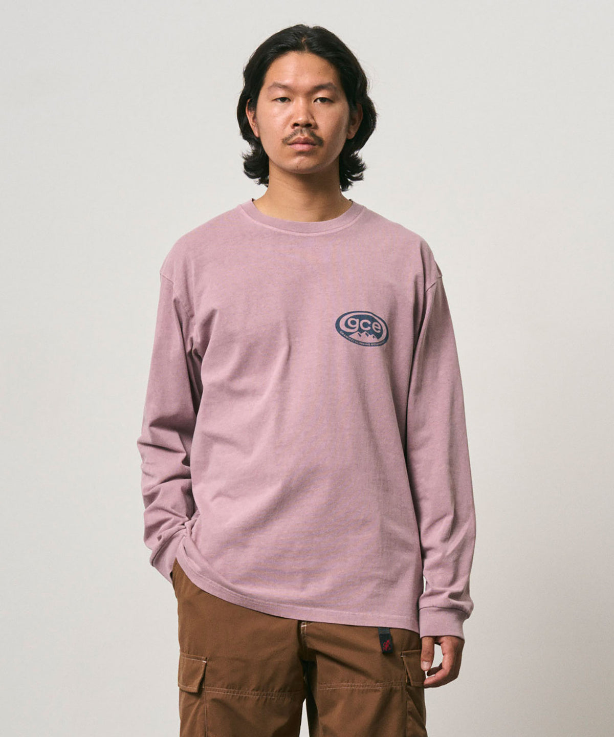 Model wearing a Gramicci lilac pigment GCE Long Sleeve Tee Pigment Dyed against a light-tone background.