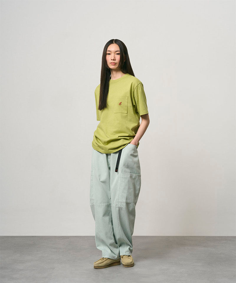 Model wearing a sweet pea colored Gramicci One Point Tee and light green pants on a light-tone background.
