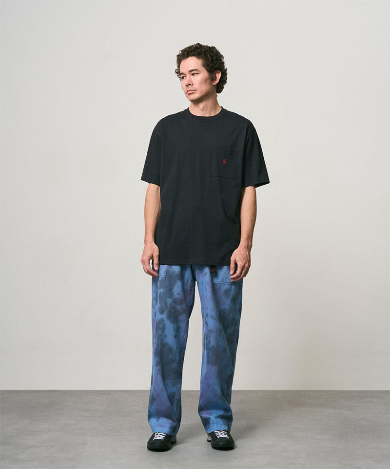 Model wearing a vintage black Gramicci One Point Tee and blue pants on a light-tone background.