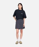 Model wearing a Gramicci G-Skort in the color fossil grey and a black shirt on a light-tone background.